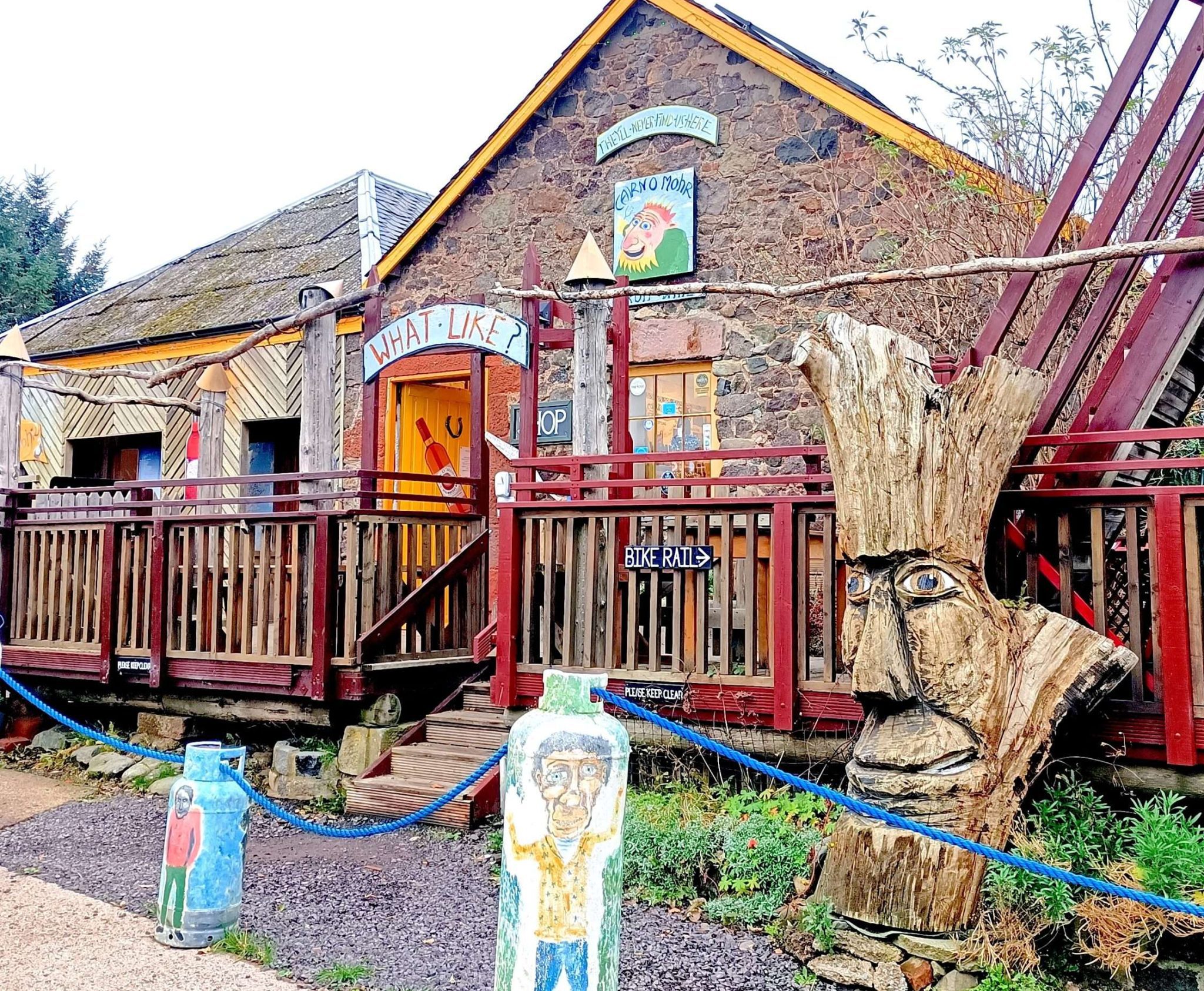 Quirky winery building. With old brick walls and bright colours and colored wooden painted fun statues
