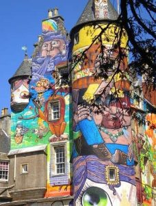 An old castle with very bright coloured graffitti painted on it
