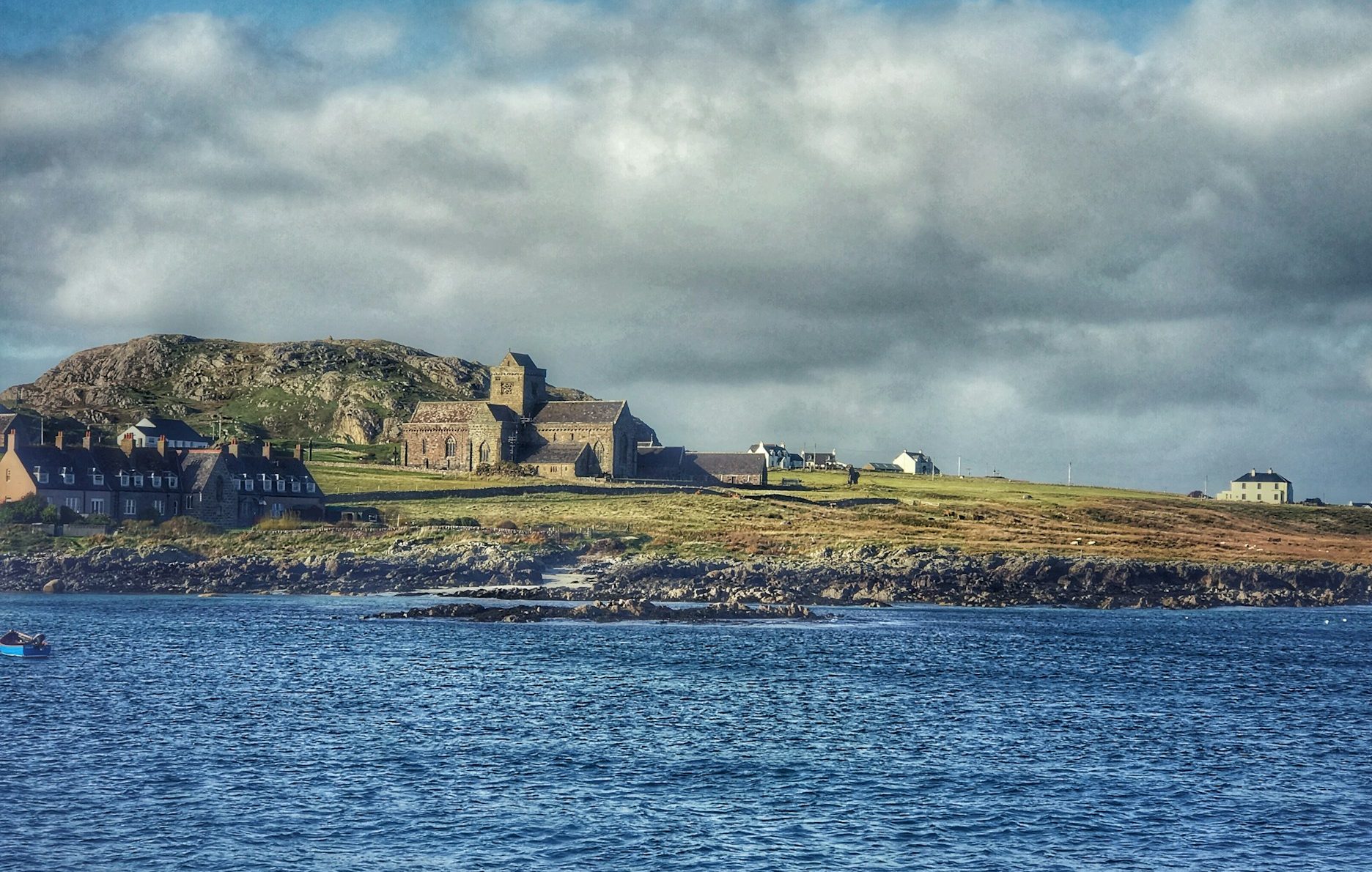 Abbey in the distance with a gentle sea in the foreground